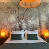 Le lit et le papier peint panoramique "Forêt"